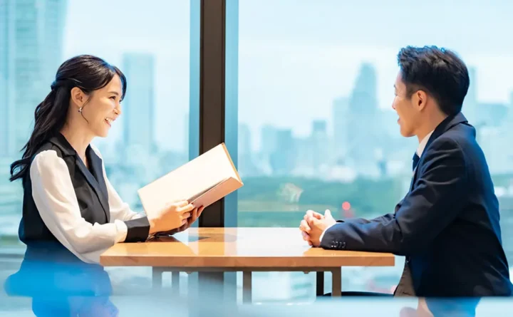 婚活のお見合い場所イメージ｜ホテルラウンジで男女が談笑し、女性がメニューを持つ場面