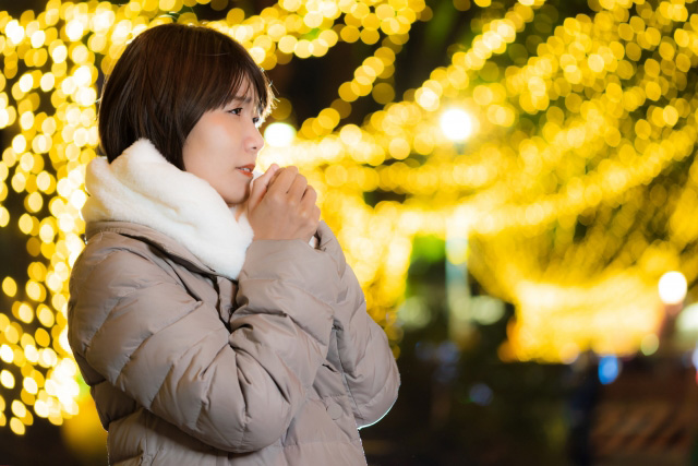 クリスマスの寒い屋外でデート相手を待つ女性