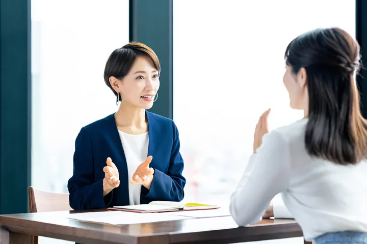 結婚相談所でカウンセラーと向き合い、真剣に婚活の相談をする女性。安心感と信頼が伝わるシーン