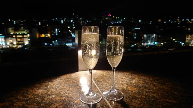 夜景の見えるレストランで乾杯する場面。告白にふさわしいロマンチックな雰囲気を表現したシーン