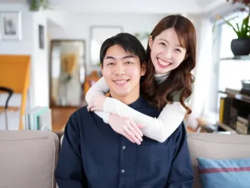 笑顔で男性を後ろから抱きしめる女性
