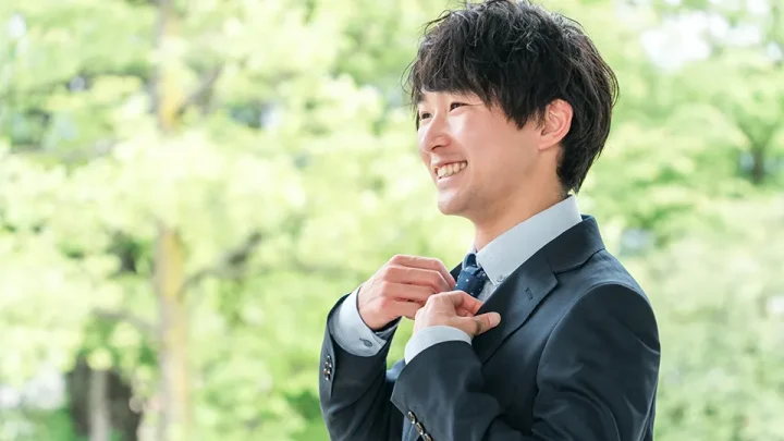 新緑の中で微笑む20代男性