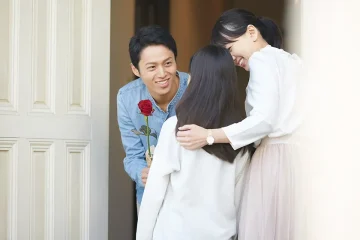 玄関で母娘を出迎える男性
