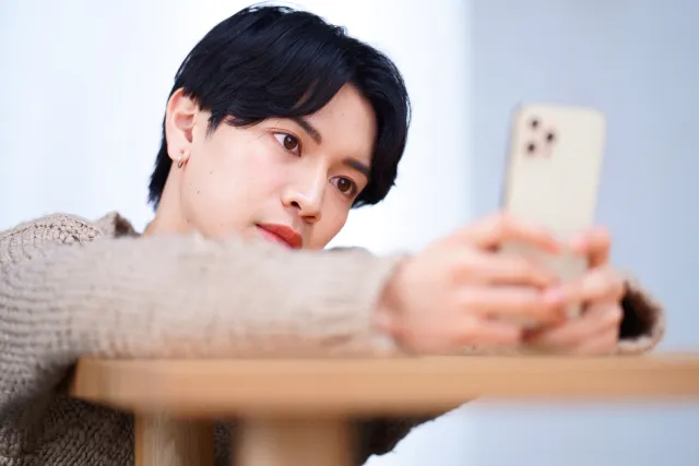 寂しそうにスマホを見る男性
