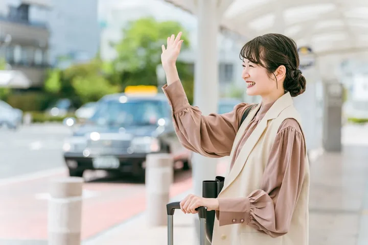 駅のターミナルで手を振る女性