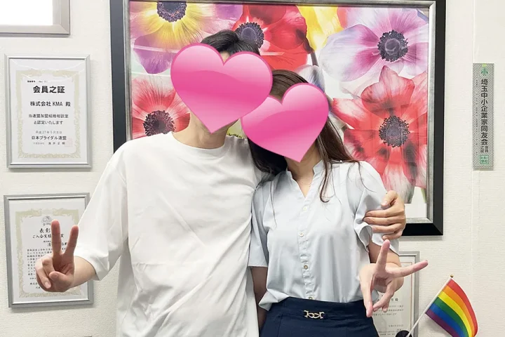 成婚手続きに来社した40代カップル｜ハートで顔を隠した幸せいっぱいのツーショット