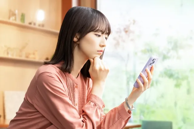カフェでスマホを見ながら悩む女性の横顔を写した、婚活がうまくいかない人のイメージ写真