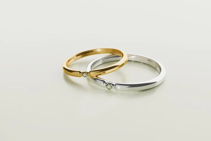 金色とシルバーの結婚指輪が白いテーブルに重なった写真。結婚相談所の離婚率が低い理由を象徴するイメージ