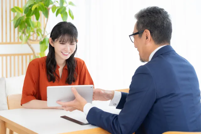 年配の講師が開業希望者と向き合い、結婚相談所の独立開業について丁寧に説明している様子。関東婚活支援協会KMA総本部が提供する開業相談のイメージ。