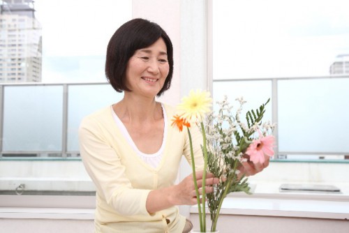 花を活けるシニア女性