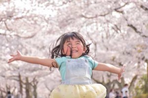 桜花吹雪の中を走り回る女の子