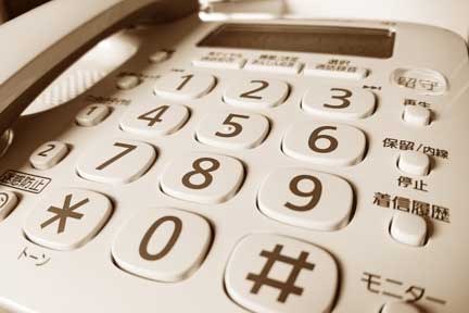 結婚相談所でお見合い相手に連絡する電話機｜愉快な留守番電話を聞く場面