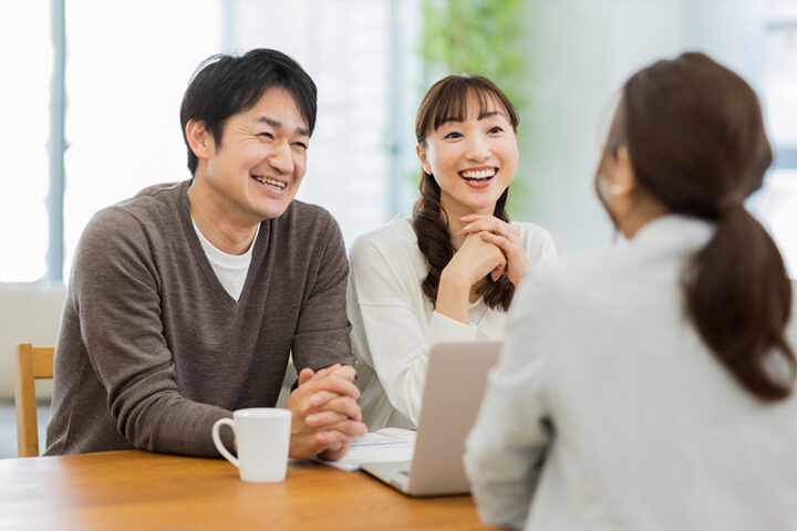 40代後半男性（初婚）と50代バツイチ子持ち女性が、結婚相談所のカウンセラーへ成婚退会の挨拶をするイメージ写真