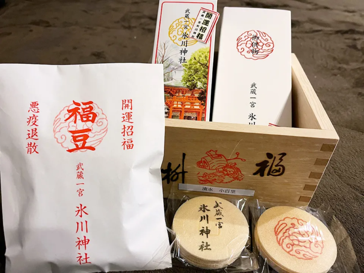 悪疫退散・開運招福と書かれた氷川神社の福豆袋と、武蔵一宮氷川神社のお供物、福枡に入ったお札が並ぶ節分祭の授与品